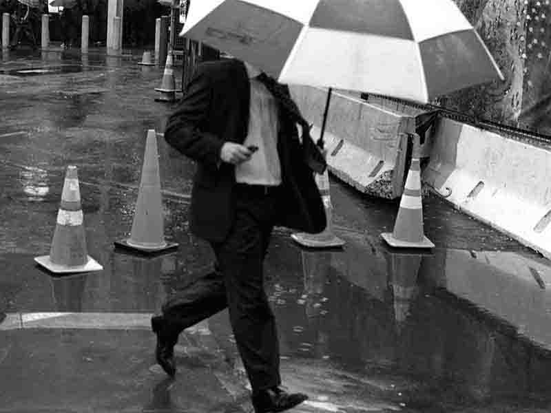 Man with umbrella running in the rain at Ground Zero New York